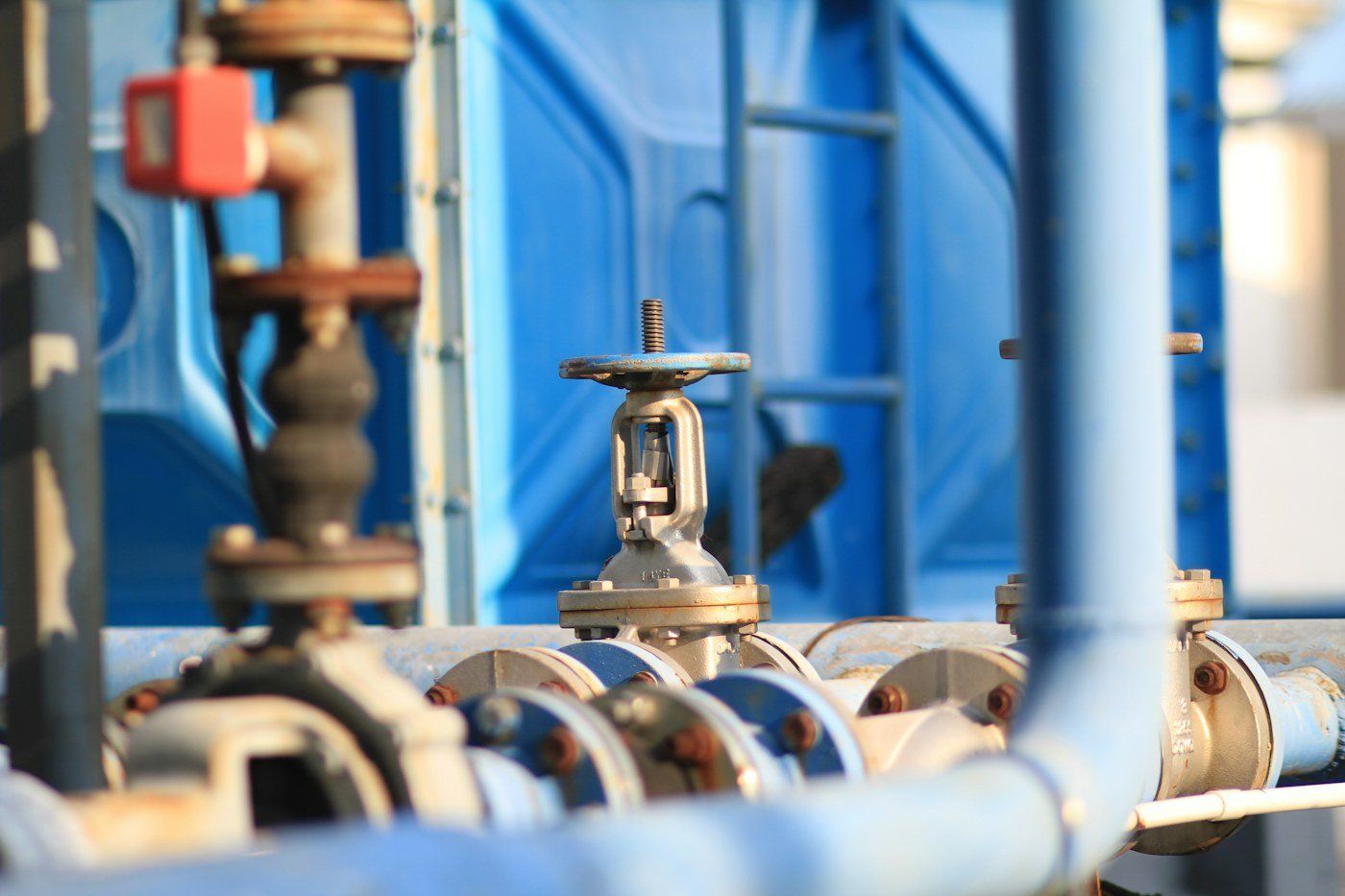 Gate valves with handwheels on blue process pipework